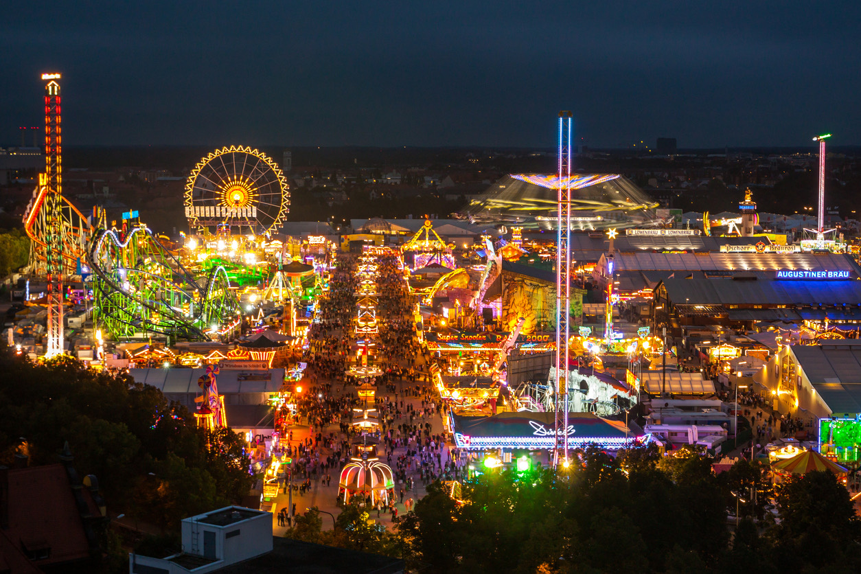 Das Oktoberfest bei Nacht aus der Vogelperspektive - beleuchtete Festzelte und Fahrgeschäfte