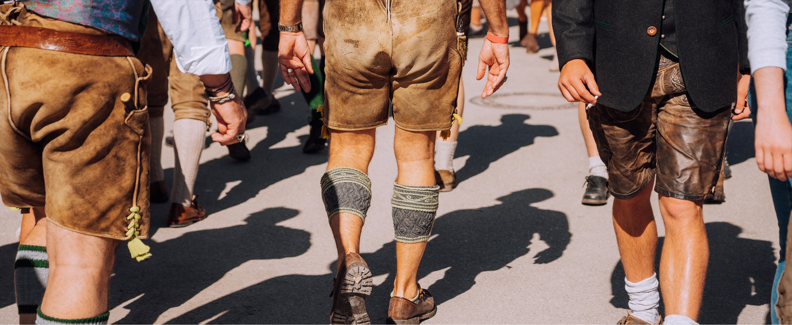 Wiesn-Besucher in Lederhosen auf dem Weg zum Festzelt